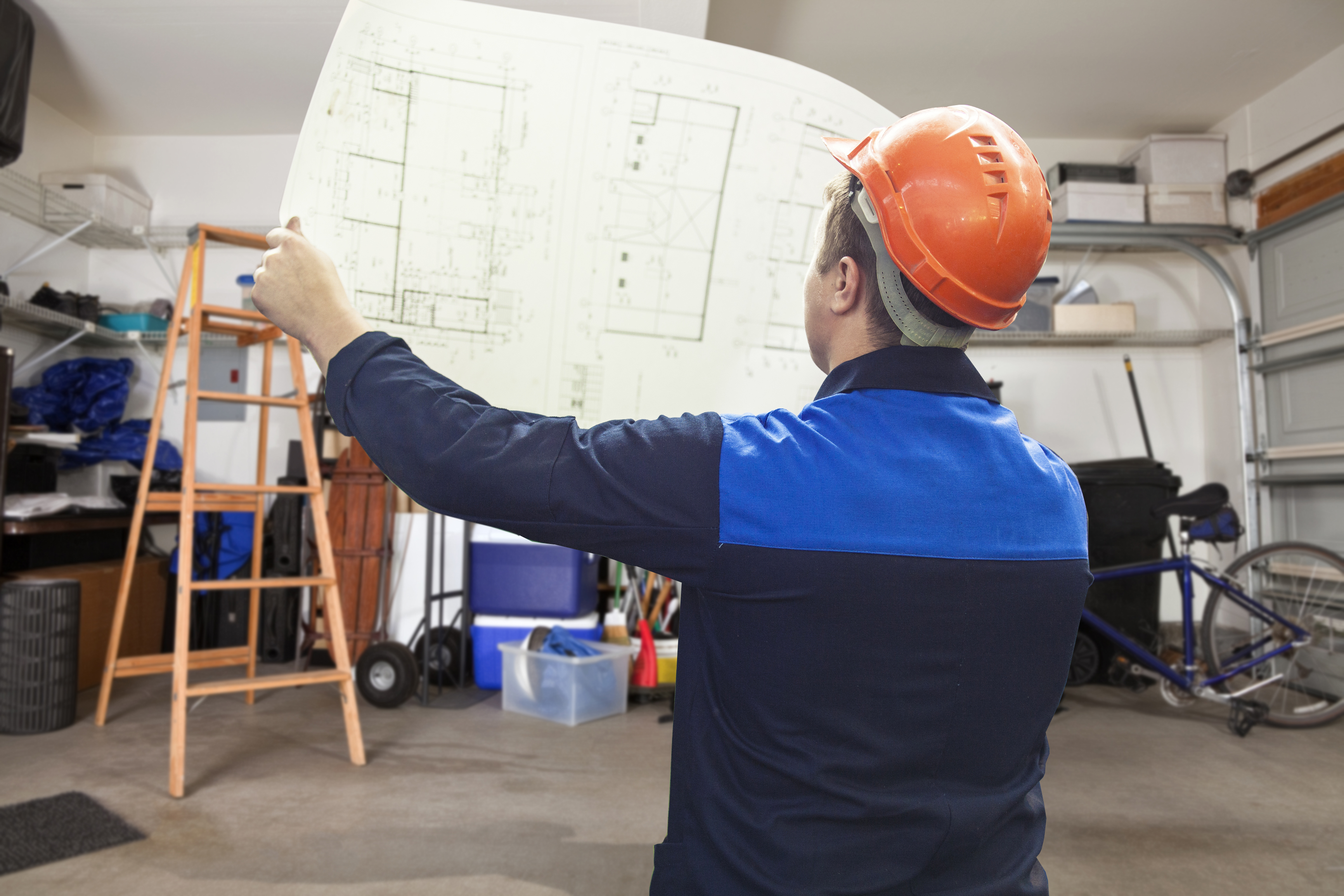 Man holding blueprint in garage